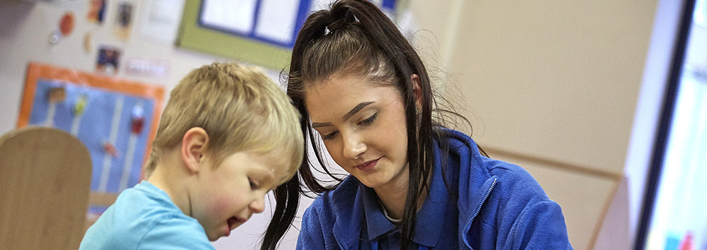 Nursery worker playing with a little boy