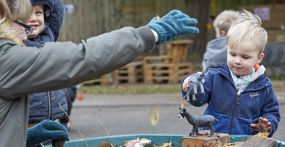 little boy playing with plastic animals at Grange Road Nursery