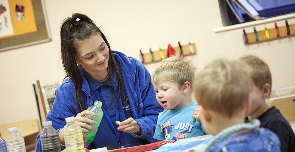 Nursery worker playing with children